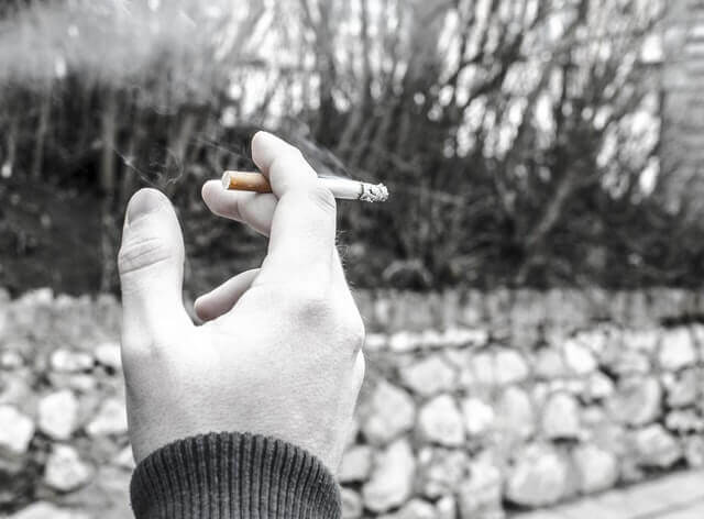 black and white image of hand holding a cigarette